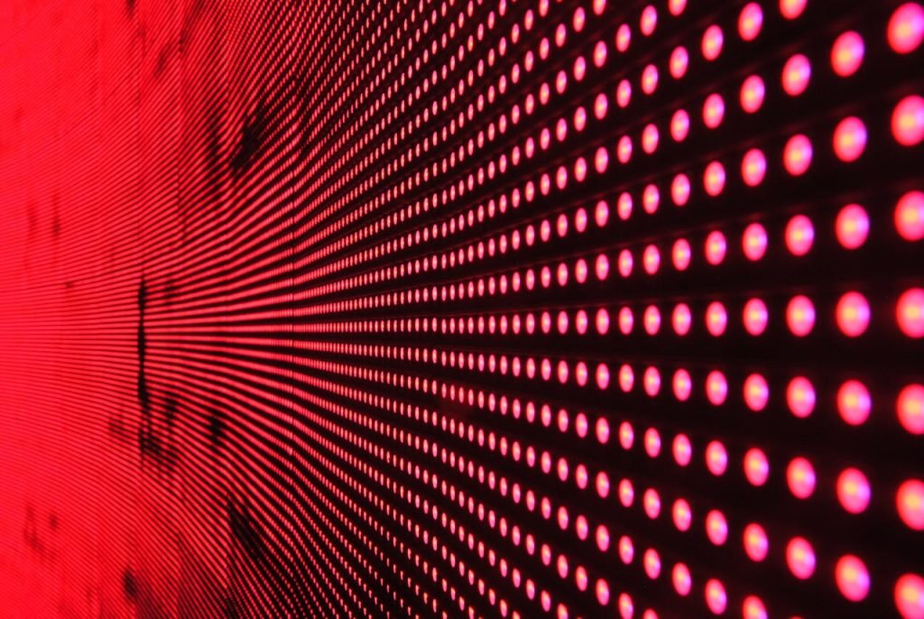 red-dot-lights-on-black-surface-158826 Vibrant abstract pattern of illuminated red LED lights forming a dynamic design.